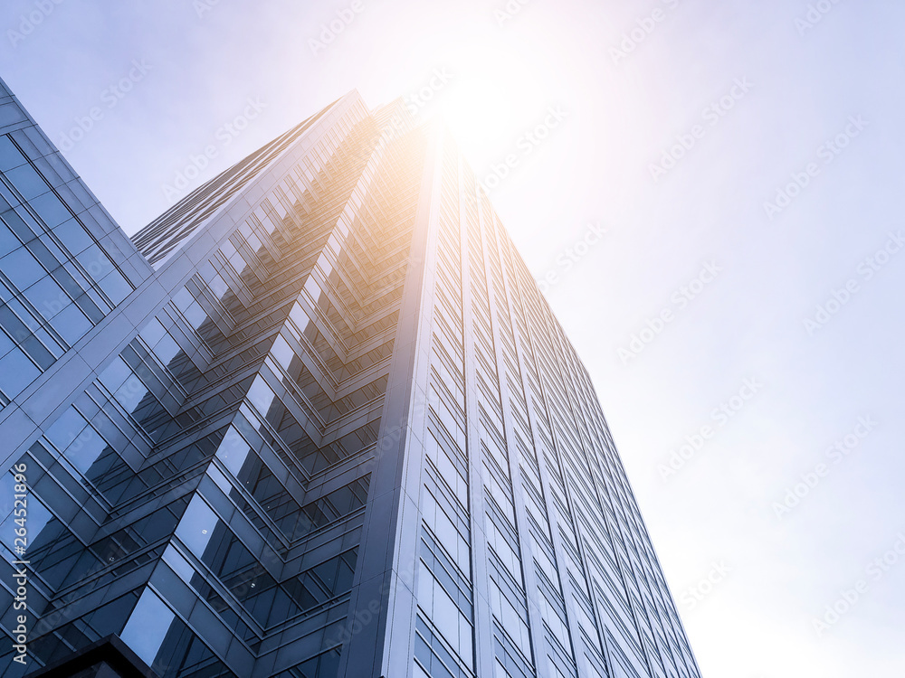 Office buildings stretch up to the sky with sunlight.