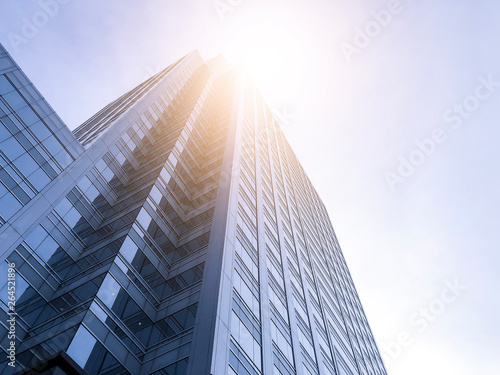 Office buildings stretch up to the sky with sunlight.