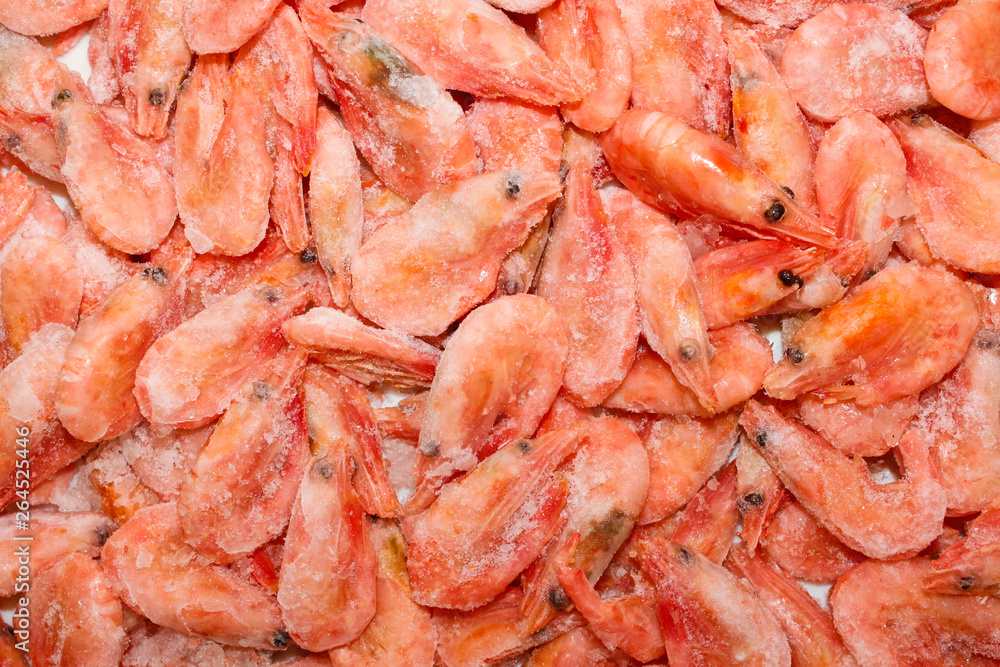 Raw shrimp background. Pile of frozen shrimps on white background.Close-up of frozen shrimps. Shrimp and ice, top view.