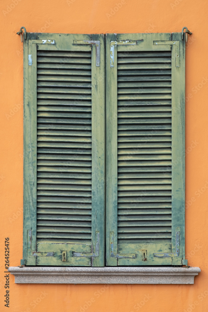 Green window shutters on orange facade