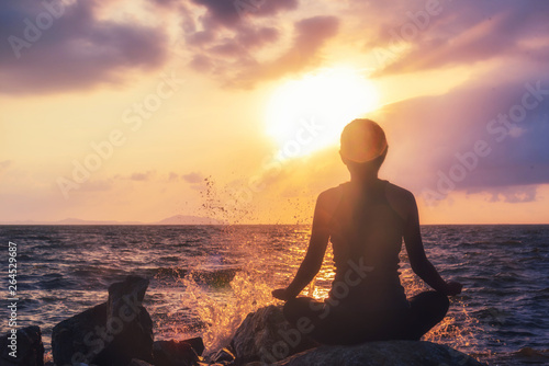 Young healthy woman practicing yoga on the beach at sunset © 2B