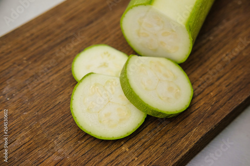 Zucchini cut in slices on a cutting board.