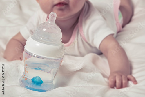 Bottle of water for baby. Infant child on blurred background