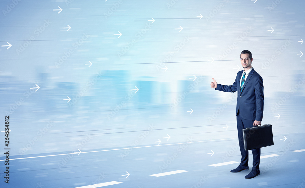 Young businessman hitchhiking near the city with arrows around concept Young businessman hitchhiking near the city with arrows around concept