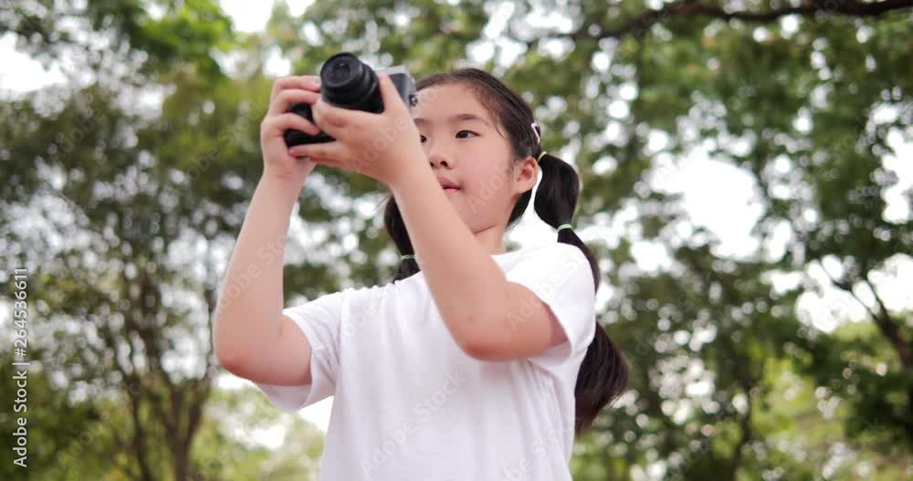 Asian little girl enjoy when using camera at park. Asian little girl enjoy when using camera at park.