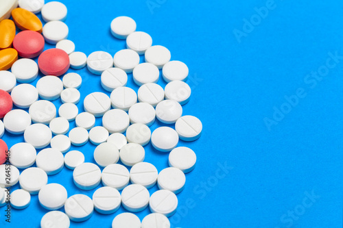 Medicine pills or capsules on blue background with copy space. Drug prescription for treatment medication