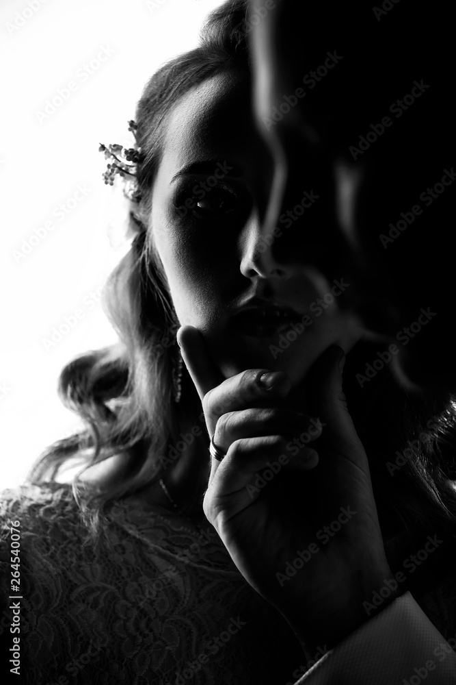 Closeup portrait of bride and groom. A man holds a beautiful girl by the chin Closeup portrait of bride and groom. A man holds a beautiful girl by the chin