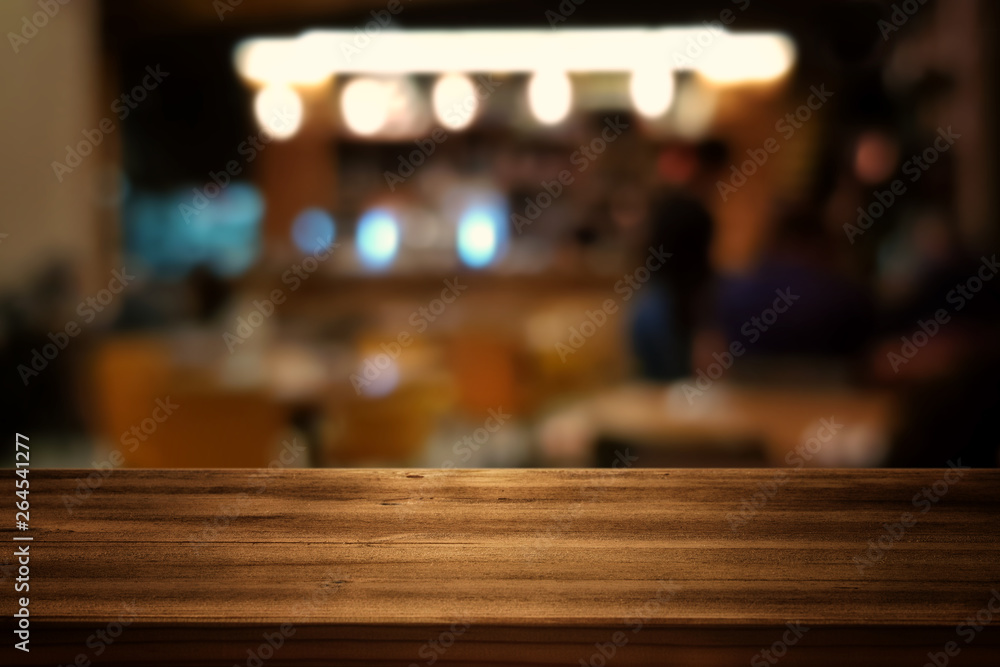 Image of wooden table in front of abstract blurred restaurant lights background Image of wooden table in front of abstract blurred restaurant lights background