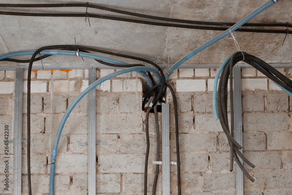 Electrical wires hanging off the ceiling and wall with metal profile for plasterboard drywall Electrical wires hanging off the ceiling and wall with metal profile for plasterboard drywall