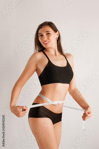 Slender girl with a tape measure around the waist © Stanislaw Mikulski