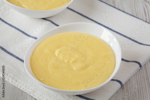 Homemade vanilla custard pudding in white bowls, low angle view. Close-up.