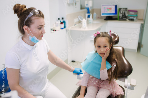 Little girl have a toothache. Dentist will help to the patient