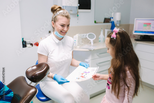 Little girl show to dentist a picture