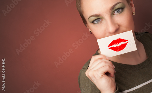 Photo Person smiling with a card on the front of his mouth with a red lips on it