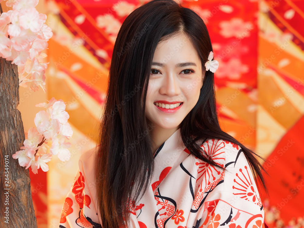 Portrait of attractive Chinese woman wearing traditional Japanese Kimono, smiling at camera, oriental beauty. Portrait of attractive Chinese woman wearing traditional Japanese Kimono, smiling at camera, oriental beauty.