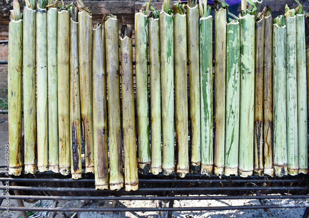 Bamboo sticks packed with sticky rice, warm water and coconut milk, burnt to make sweet sticky rice