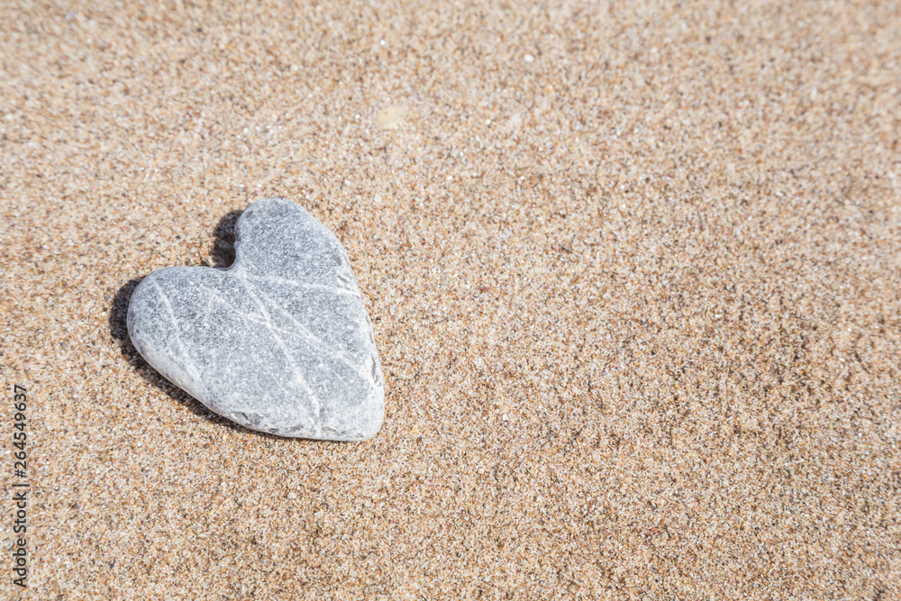 naturally heart shaped stone on sand