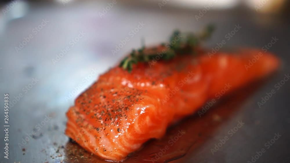Perfect slice of salmon fillet steak raw fish meat covered in oil and spices isolated on kitchen table in close up Perfect slice of salmon fillet steak raw fish meat covered in oil and spices isolated on kitchen table in close up