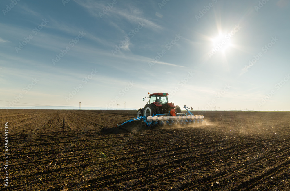  Farmer with tractor seeding soy crops at agricultural field