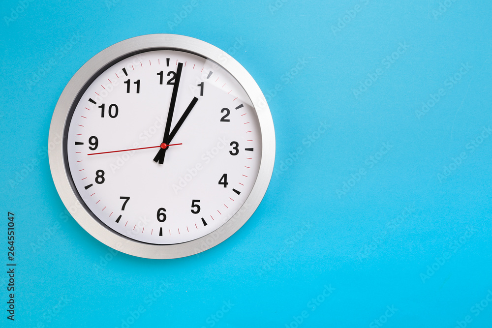Closeup wall clock set on blue background. The concept of Closeup wall clock set on blue background. The concept of