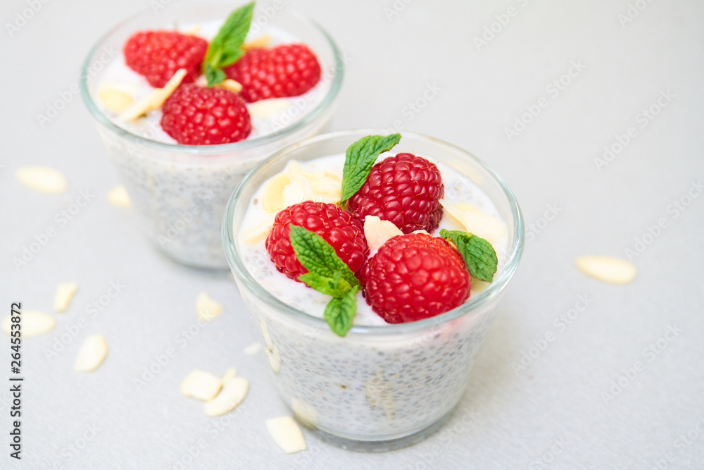 chia pudding with raspberries in a small glass bowl chia pudding with raspberries in a small glass bowl