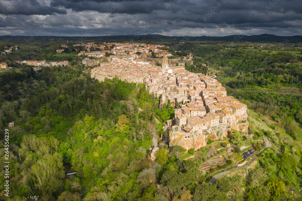 Fly above old city in Tuscany in Italy in spring sunset.