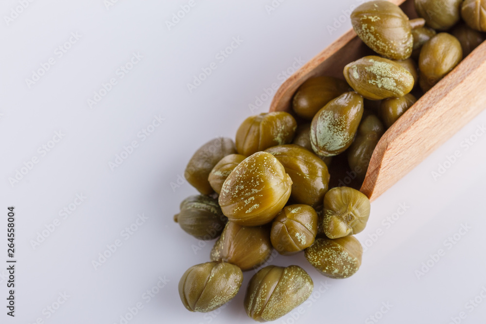 Pickled capers on a white acrylic background Pickled capers on a white acrylic background