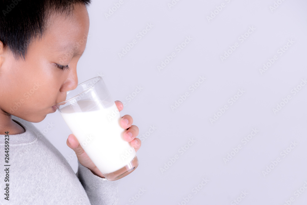 Health care and medical concept. Asian boy holding a glass of milk over white background. Health care and medical concept. Asian boy holding a glass of milk over white background.