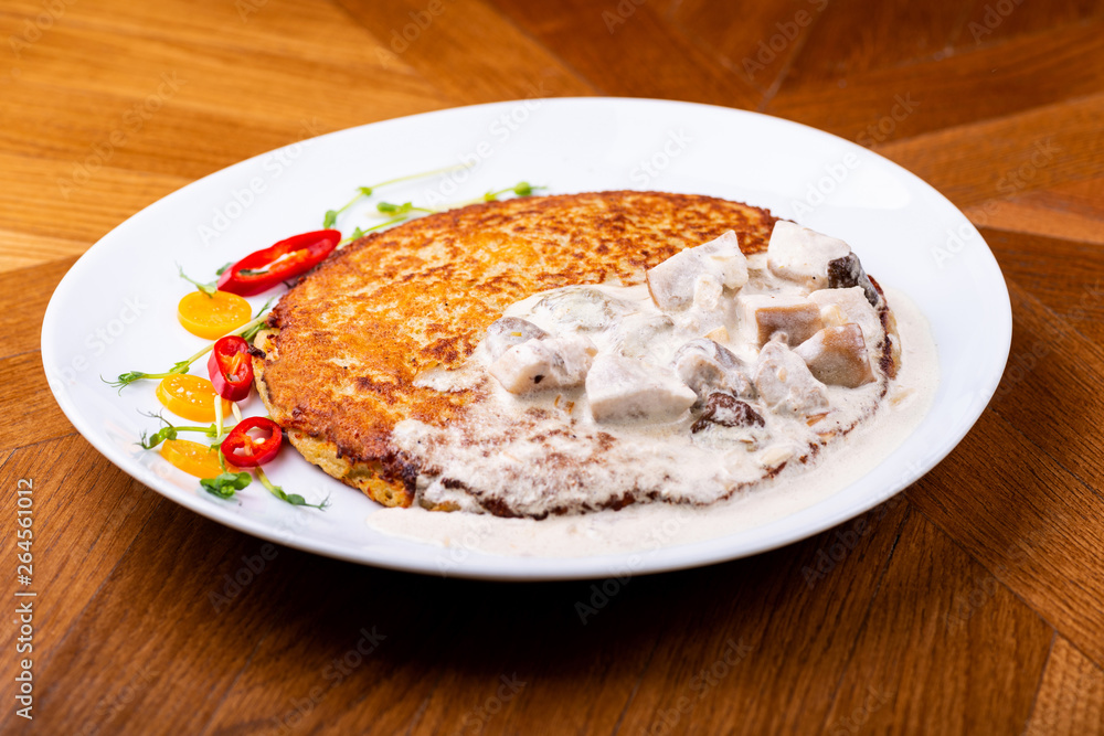 Potato pancakes in white mushroom sauce. Draniki - potato fritters. potato pancakes. The naitonal dish of Belarus, Ukraine and Russia Potato pancakes in white mushroom sauce. Draniki - potato fritters. potato pancakes. The naitonal dish of Belarus, Ukraine and Russia