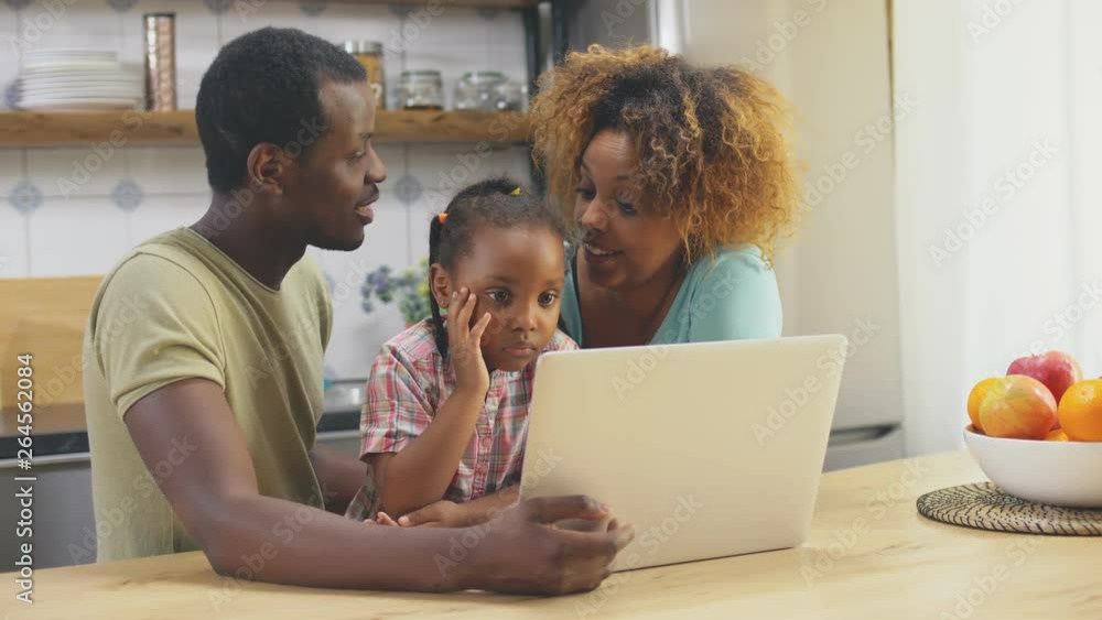 Black parents and daughter using laptop Black parents and daughter using laptop
