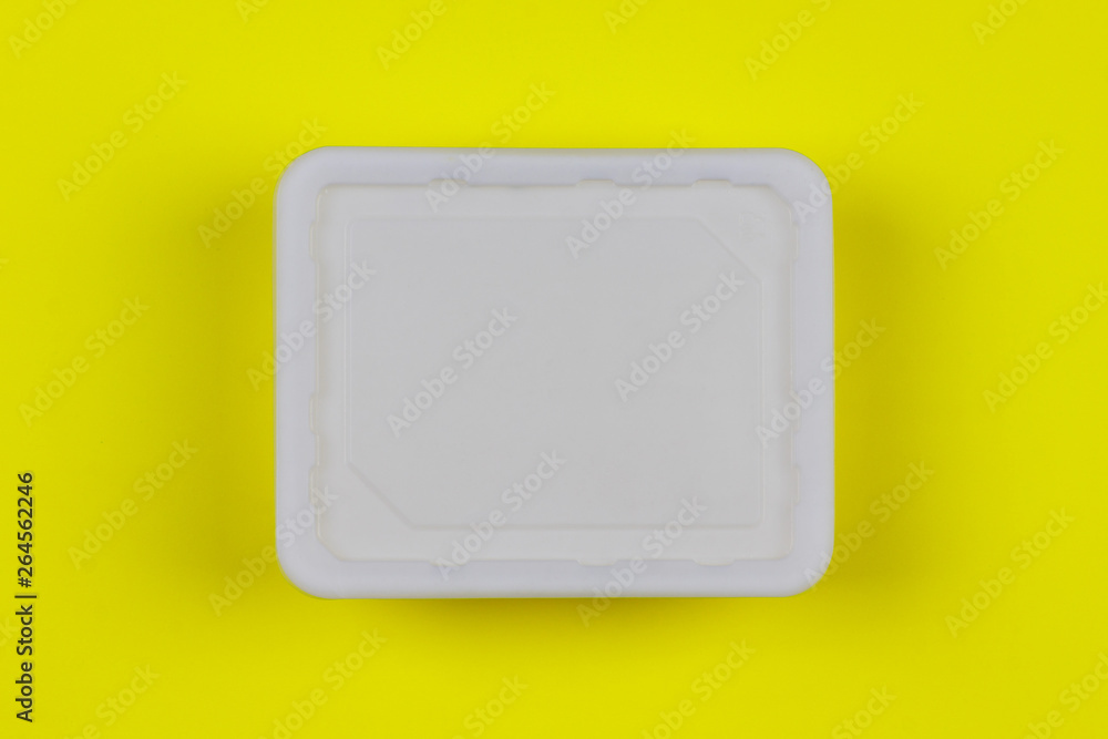 mock-up white plastic box on yellow background top view, disposable packaging for products. the concept of the problem of prohibiting the use of plastic packaging mock-up white plastic box on yellow background top view, disposable packaging for products. the concept of the problem of prohibiting the use of plastic packaging