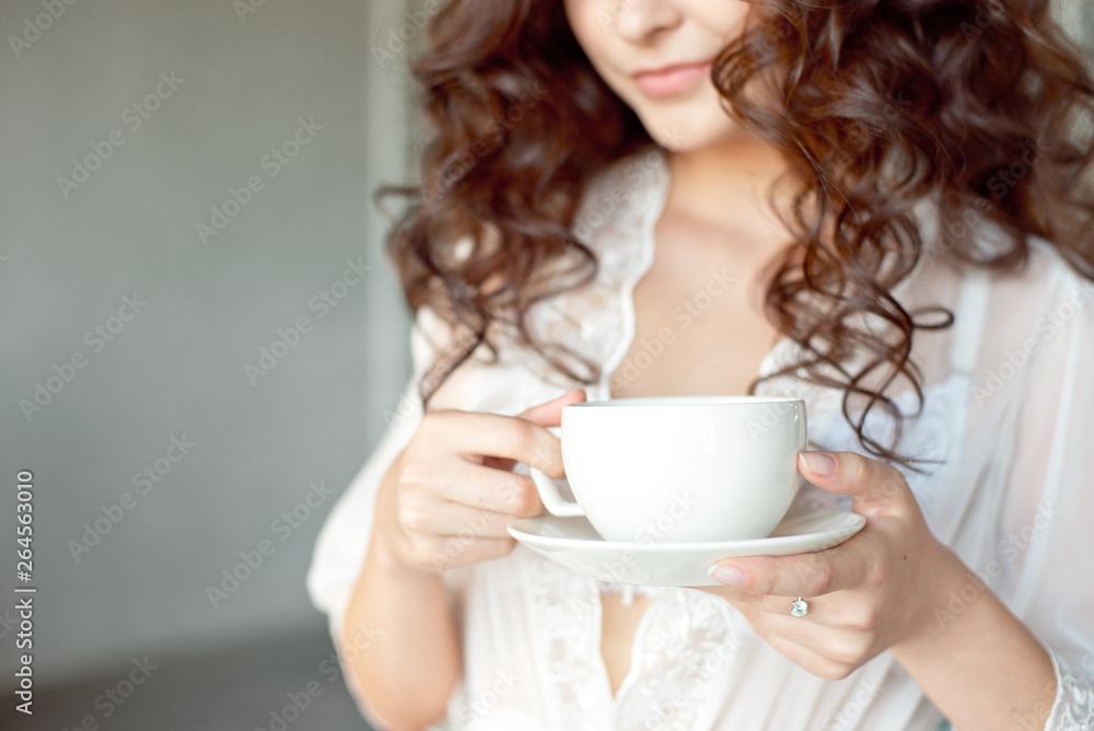 Close-up of a white Cup of hot latte art coffee with a heart shape in the hands of a young girl Close-up of a white Cup of hot latte art coffee with a heart shape in the hands of a young girl