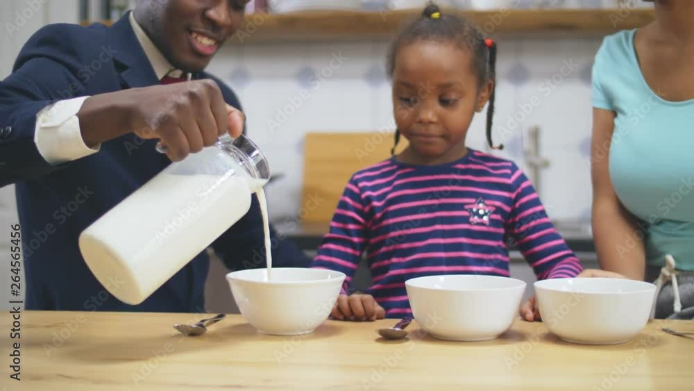 African man pouring milk in plates African man pouring milk in plates