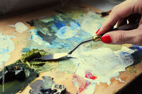 Blending with a palette knife of green paint on the palette