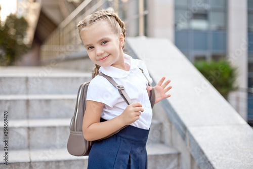 Happy smiling girl is going to school for the first time with bag go to elementary school.