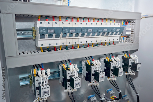 Series of Fuse holders, contactors or magnetic starters with front additional contacts, cylindrical capacitors in the electric reactive power compensation Cabinet. Wires are connected to the project.