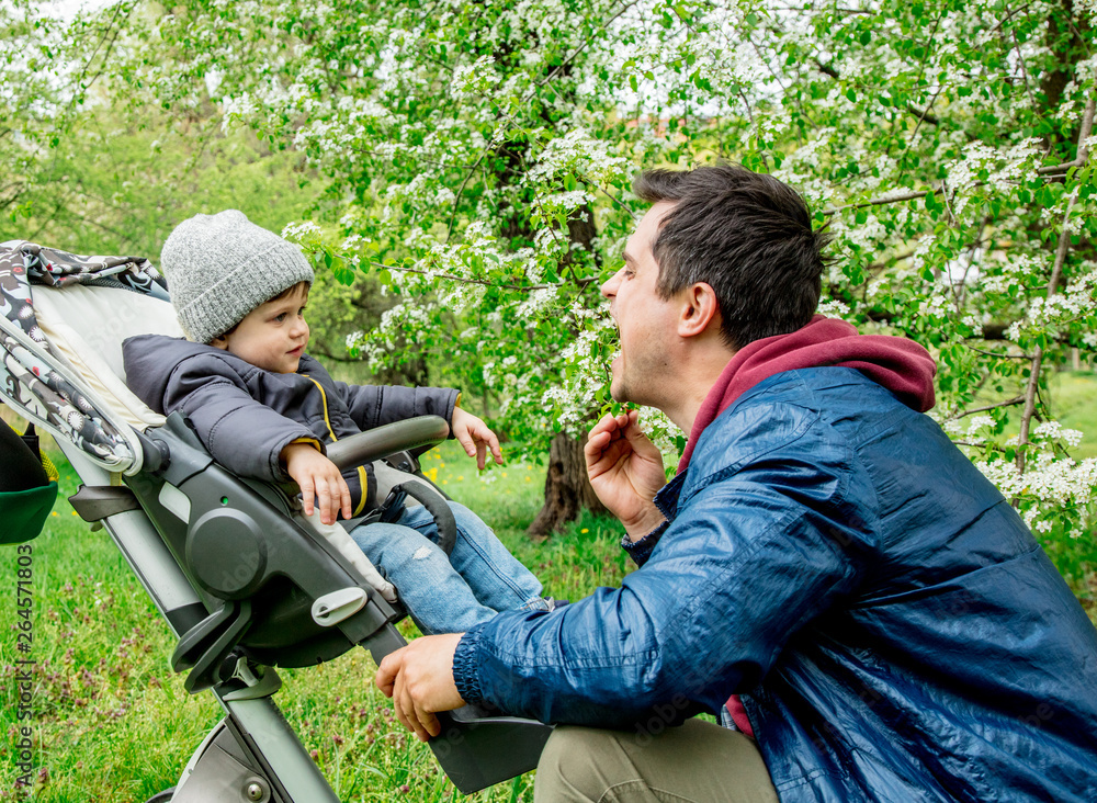 Young father and son in baby carriage Young father and son in baby carriage