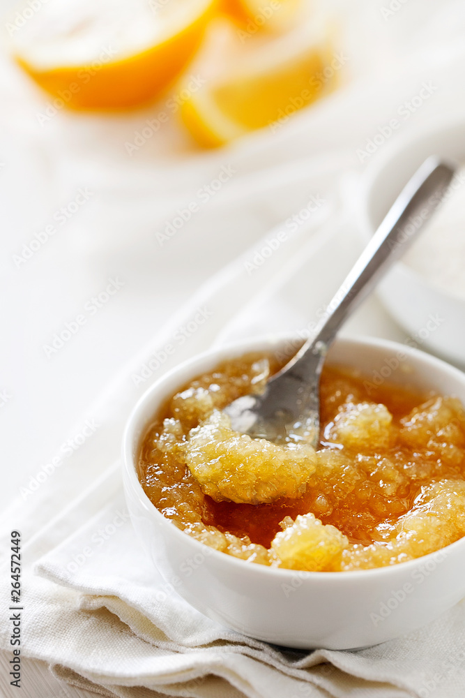Trendy healthy homemade citrus lemon jam or confiture in a bowl on a white wooden background close-up.Delicious dessert for Breakfast. Fruit preservation.Vertical orientation Trendy healthy homemade citrus lemon jam or confiture in a bowl on a white wooden background close-up.Delicious dessert for Breakfast. Fruit preservation.Vertical orientation