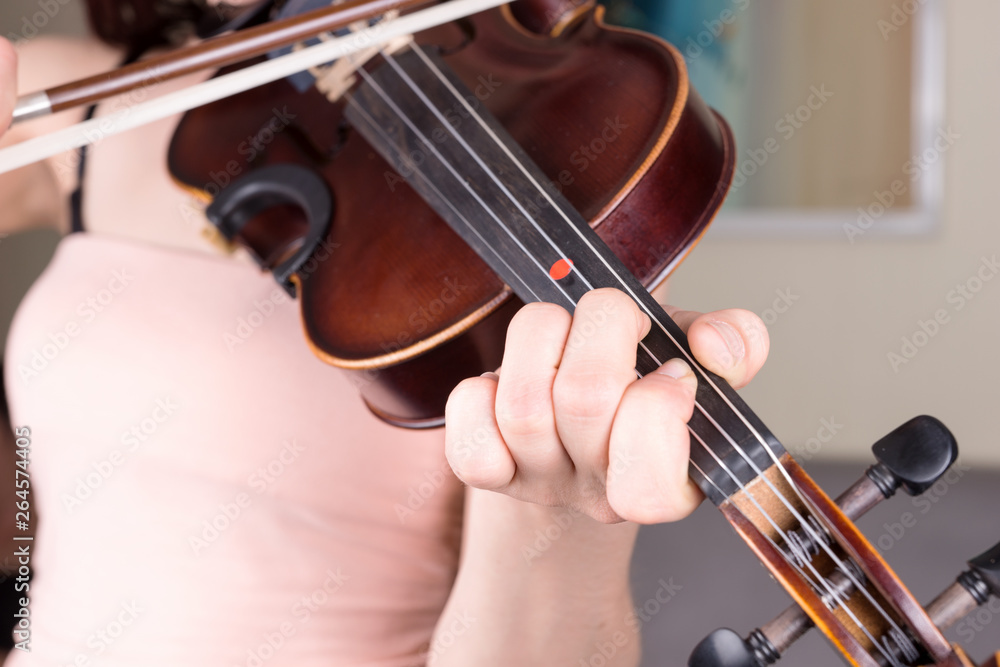 Young woman hand playing classical violin. Teen girl learning to play song Young woman hand playing classical violin. Teen girl learning to play song