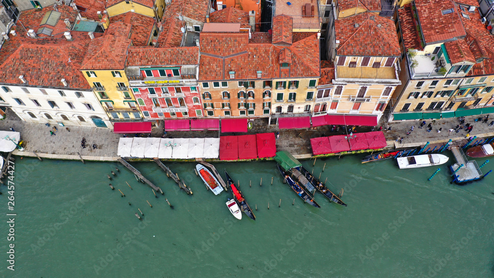 Aerial drone top view photo of iconic and unique colourful Gondolas in Grand Canal near Rialto bridge, Venice, Italy