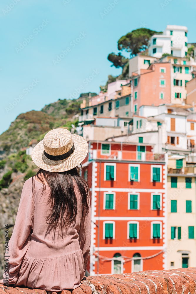 Young woman with great view at old village Riomaggiore, Cinque Terre, Liguria