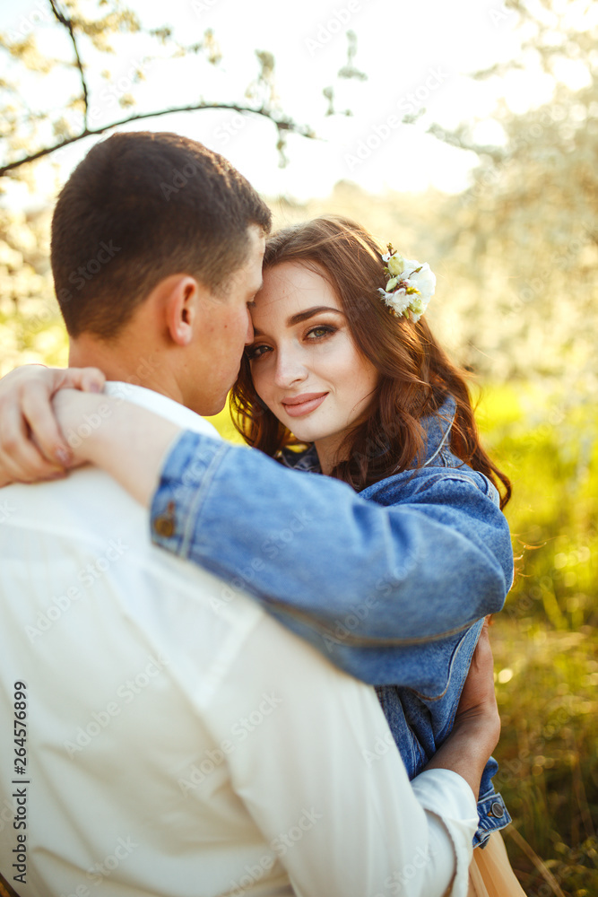 Beautiful loving couple in the blooming gardens. Wedding concept. Great sunset light. Lovely newlyweds. Beautiful loving couple in the blooming gardens. Wedding concept. Great sunset light. Lovely newlyweds.