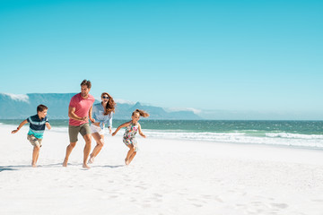 Happy family running on beach
