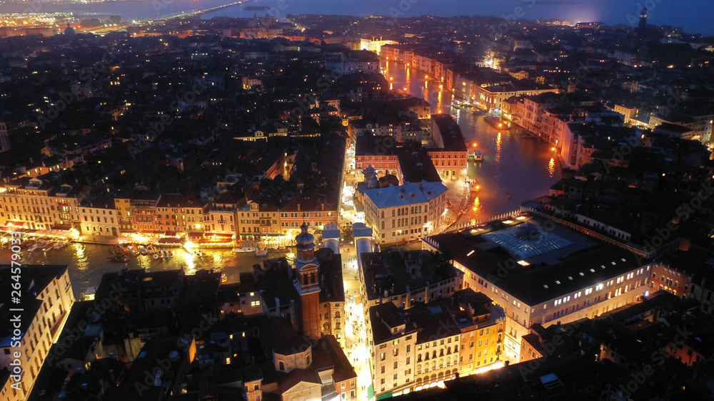 Aerial night shot of iconic illuminated Ponte Rialto or Rialto bridge crossing Grand Canal, Venice, Italy