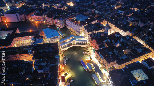 Aerial night shot of iconic illuminated Ponte Rialto or Rialto bridge crossing Grand Canal, Venice, Italy