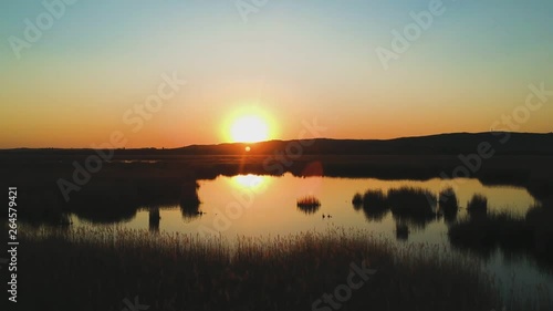 Close-up water drone view with forward movement and catching the sunset moment near in Velence Lake, Hungary. ( DJi Drone footage I 29.97 fps ) photo