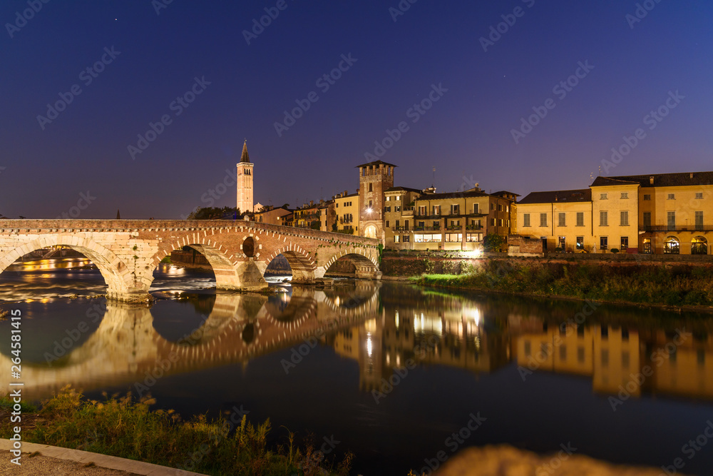 Ponte Pietra over Adige River and city at night. Verona. Italy