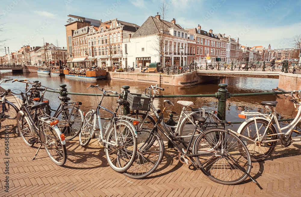 Bicycles parked on bridge through river of historical european town. the Netherlands.