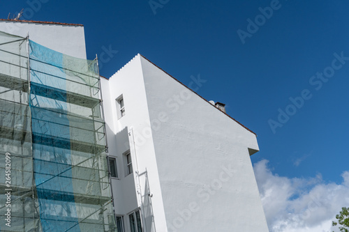 Painted building with metallic scaffolding wall
