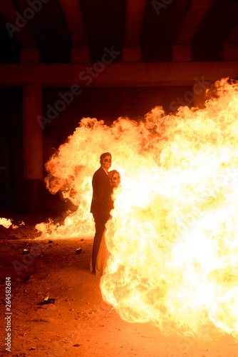 Halloween couple standing with flamethrower. big fire